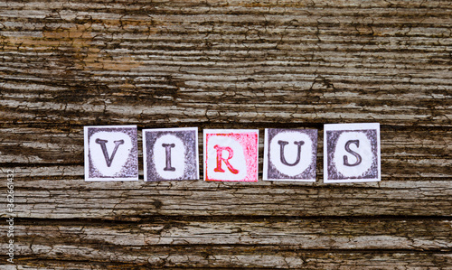 Virus text, ink stamp paper, wooden background. © rtx018