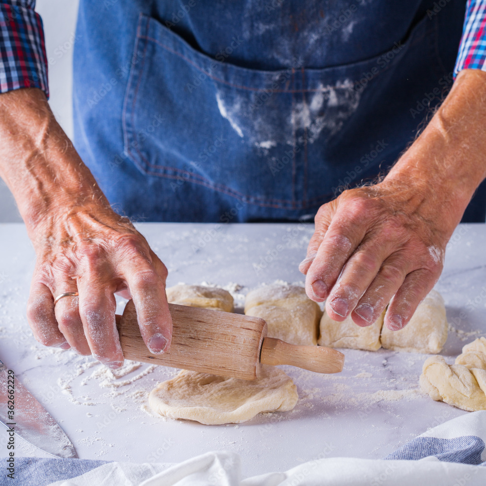 Baking at home concept. Senior man hands cooking, making dough