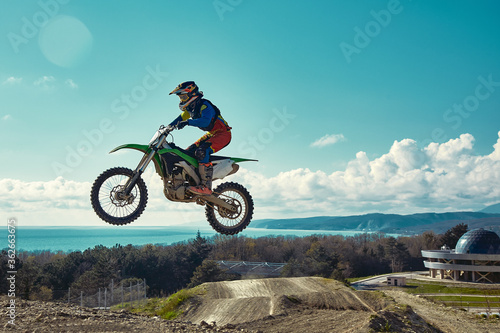 Extreme concept, challenge yourself. Extreme jump on a motorcycle on a background of blue sky with clouds. Copy space, all or nothing.