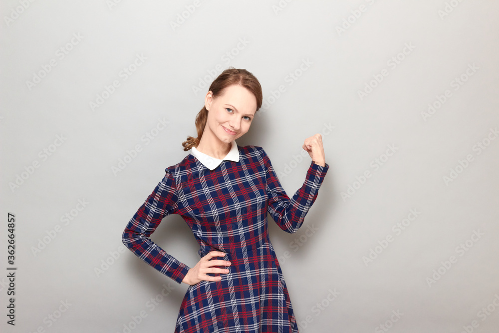 Portrait of happy young blond woman raising fist up and smiling Portrait of happy young blond woman raising fist up and smiling