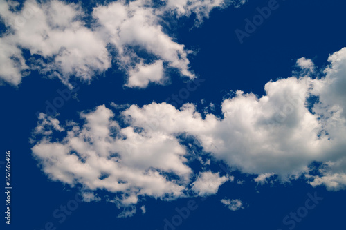 Contrast cumulus clouds. A group of clouds on a blue windy sky. Natural sky background.