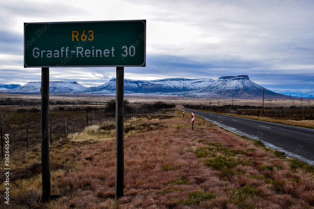 Road sign on an open road with snowy mountains in the background. Road sign on an open road with snowy mountains in the background.