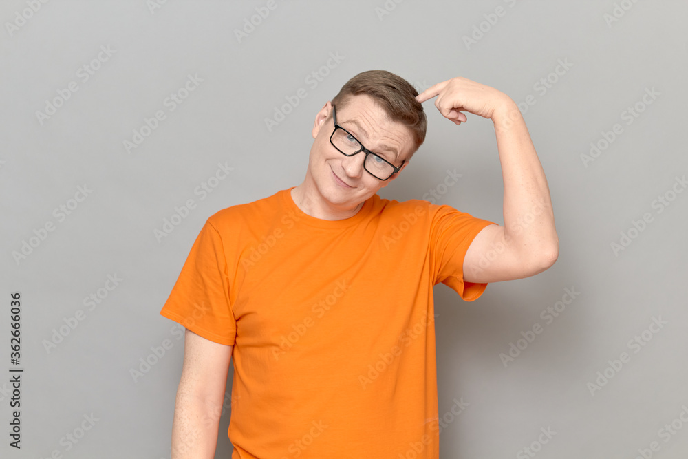 Portrait of happy mature man touching head with finger and thinking Portrait of happy mature man touching head with finger and thinking