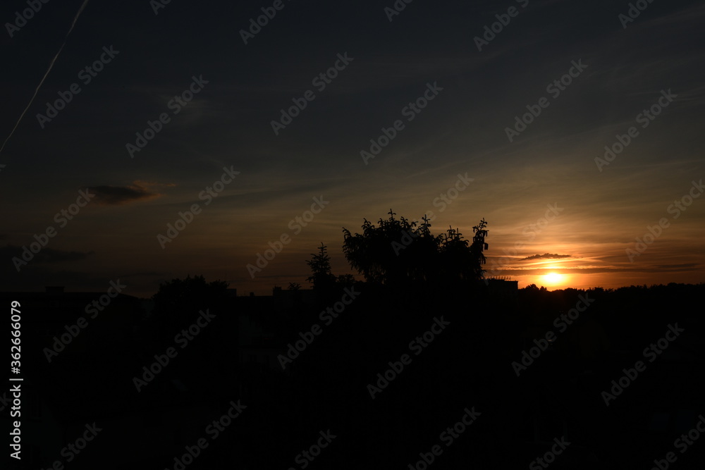 colorful sunset with red sky and trees and clouds colorful sunset with red sky and trees and clouds