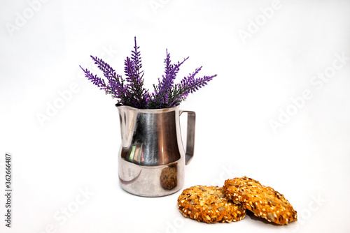 Pitcher milkman steel. lavender and spicy oatmeal cookies on a white background photo
