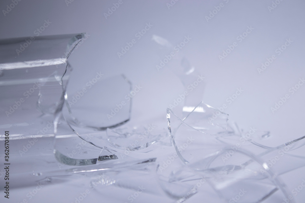 pieces of broken glass are scattered on a gray-white background. High quality photo pieces of broken glass are scattered on a gray-white background. High quality photo