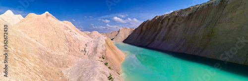 Panoramic photo of the canyon among the sands with turquoise water. Wallpaper, screen saver, cover.