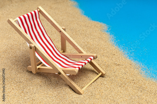 Fototapeta Naklejka Na Ścianę i Meble -  Beach chairs on pastel blue background. Summer vacation, travel. Miniature chair.