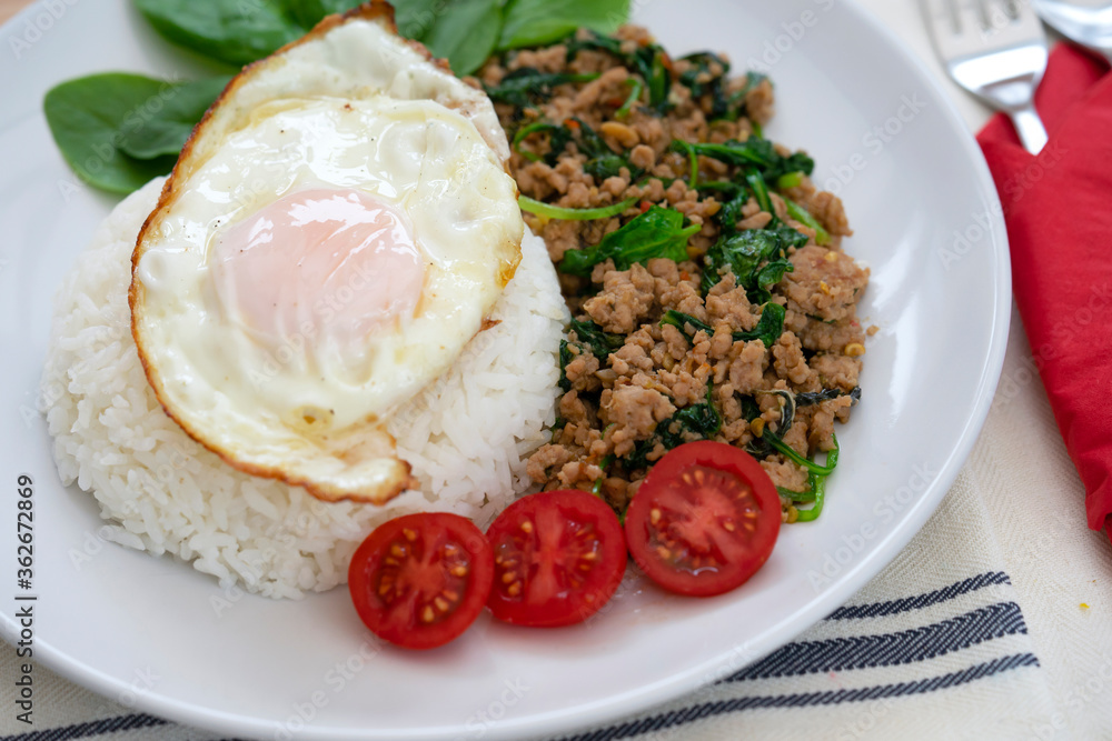 Homemade Stir fried minced pork with basil served with steamed jasmin rice and fired egg, Thai famous spicy food, Thai name is Pad kra pao Kai dow Homemade Stir fried minced pork with basil served with steamed jasmin rice and fired egg, Thai famous spicy food, Thai name is Pad kra pao Kai dow