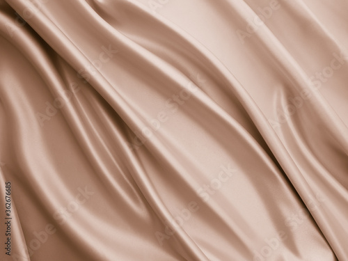 Photography of beautiful smooth elegant wavy beige / light brown satin silk luxury cloth fabric texture, abstract background design. Copy space. Card or banner