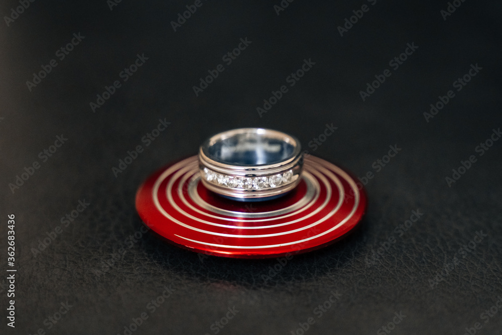 Groom's ring on a decorative disk stand Groom's ring on a decorative disk stand