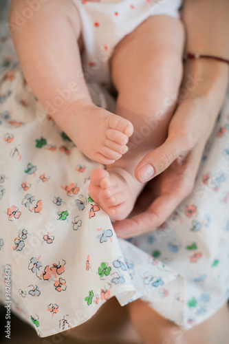 Female hand holding newborn baby's feet. Mother with his baby. Family, birth concept. Health, care, love, relationship concept. Close up (Soft focus and blurry)