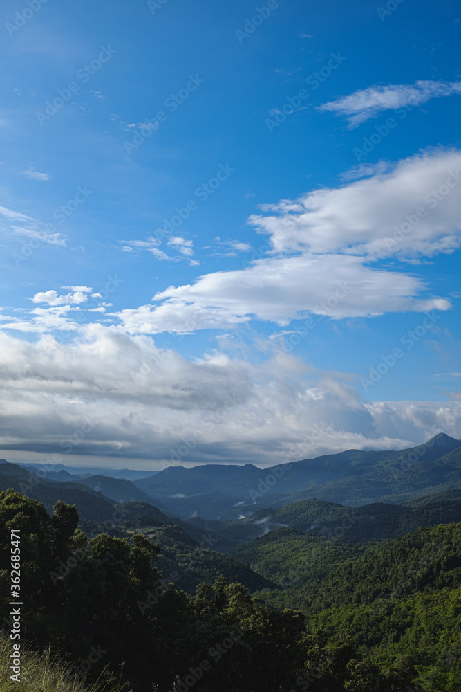 Blue sunny landscape with some mountain clouds covering mountain peak in Montseny, Catalonia