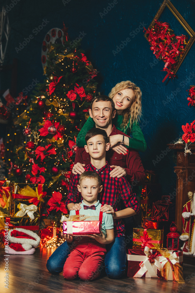 A family with two sons in a new year or Christmas interior A family with two sons in a new year or Christmas interior