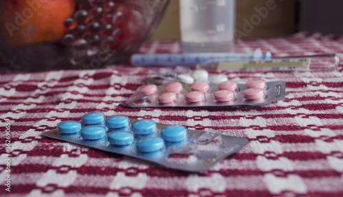 Tablets against coronavirus. Thermometer on the table. Coronavirus tablets. Covid 2019. Covid 2020. capsule tablets. Top and side view of pills.