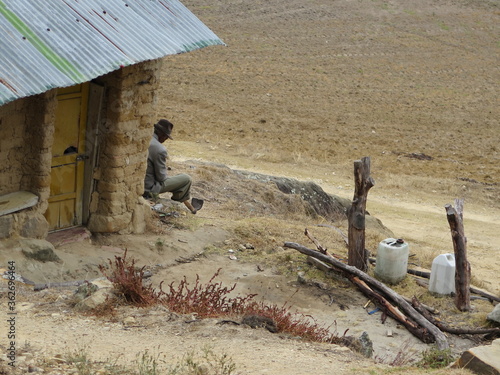 Campesino descansando  a la entrada de su casa, mientras mira el horizonte desierto, imagen costumbrista photo