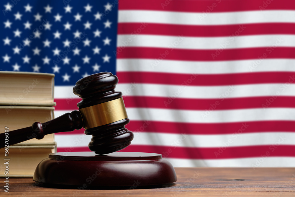 Justice and court concept in United States of America. Judge's gavel on the background of the USA flag.