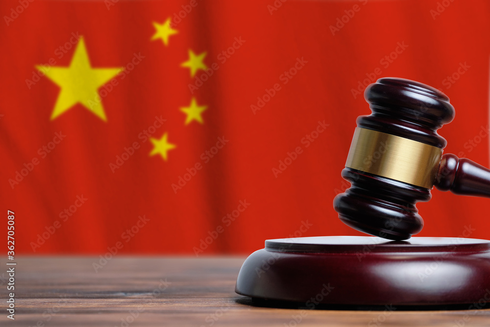 Justice and court concept in People Republic of China. Judge hammer on a flag background.