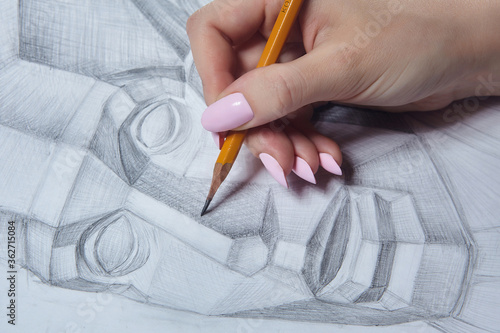 the artist's hand holds a pencil and eraser close-up.