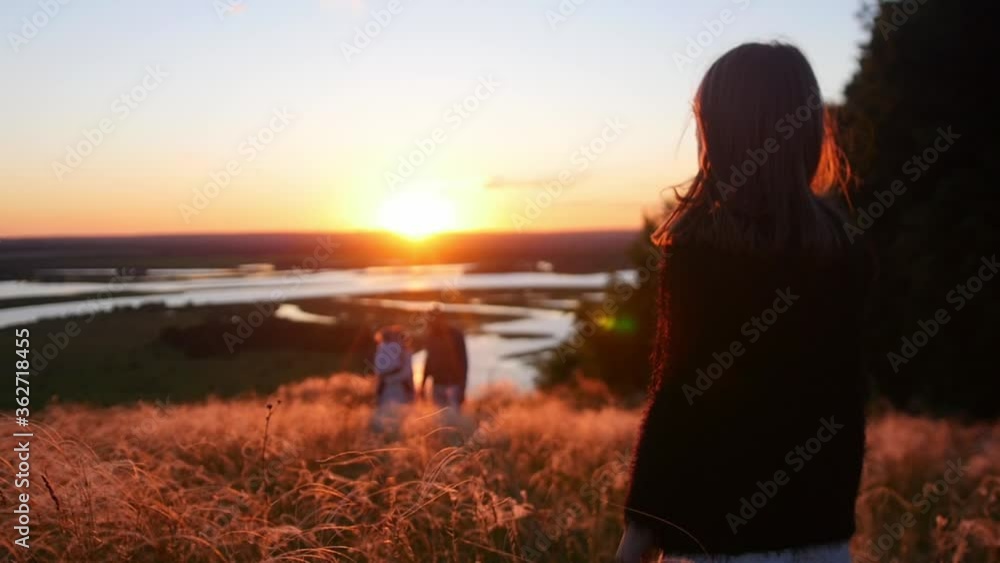 A little girl standing on the field while the sunset A little girl standing on the field while the sunset