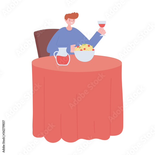 man in the restaurant eating and drinking alone because of social distancing restrictions, covid 19 pandemic