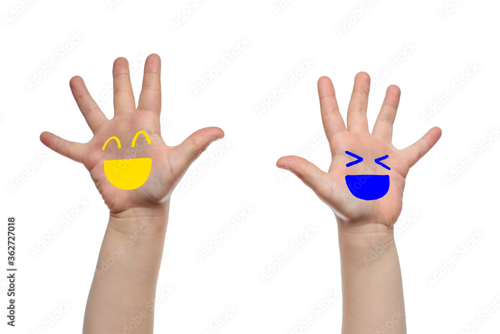 Children's hands with joyful faces painted on them Children's hands with joyful faces painted on them
