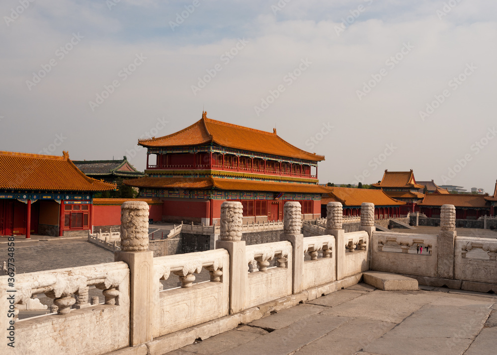 Asian-style building with red tile roof in Forbidden City with stone bridge in the foreground. Asian-style building with red tile roof in Forbidden City with stone bridge in the foreground.