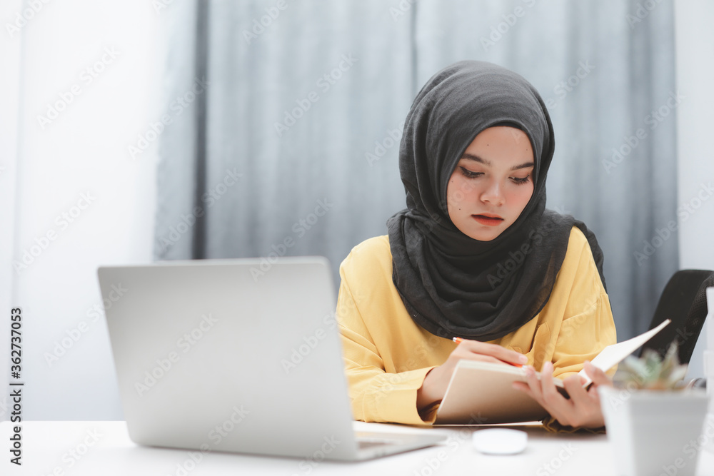 Beautiful muslim student girl using a laptop computer learning online at home. Distance learning online education. Beautiful muslim student girl using a laptop computer learning online at home. Distance learning online education.