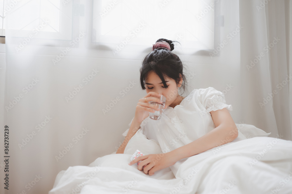 Sick woman covered with a blanket lying in bed with high fever and a flu. Sick woman covered with a blanket lying in bed with high fever and a flu.