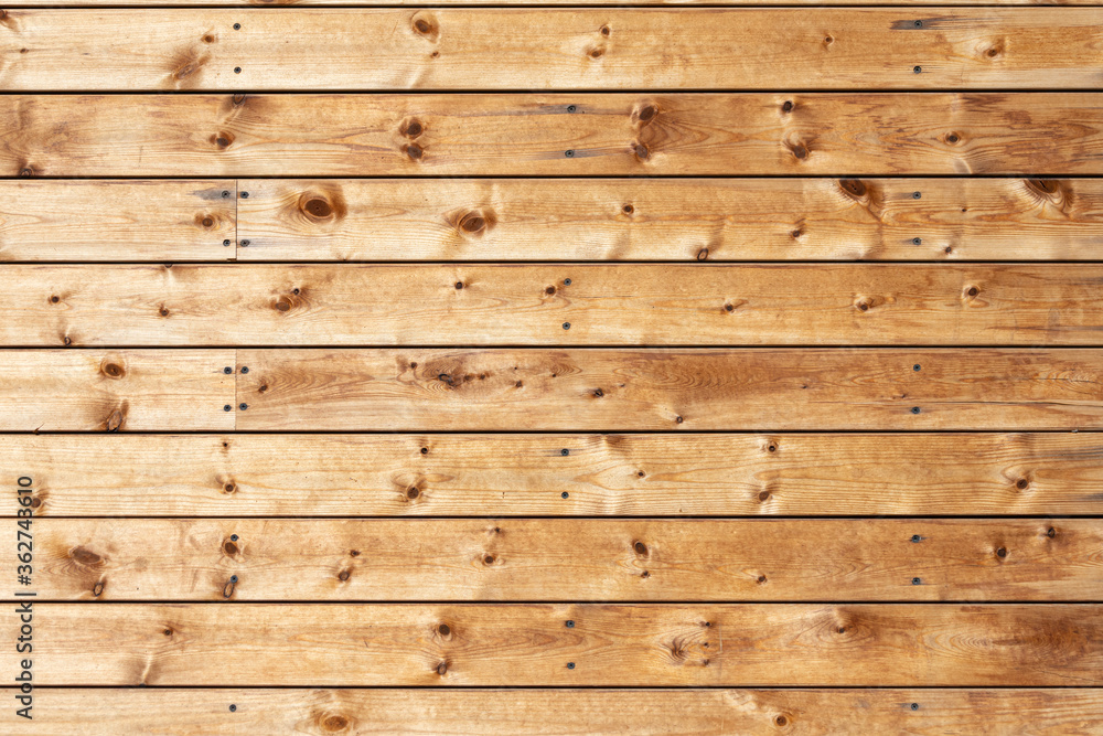 Naklejka premium Close-up of a brown horizontal wooden wall painted a very long time and the paint peeled off. Brown texture background