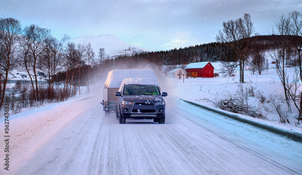 Car (SUV) moving on snowy road with small trailer at the winter - Tromso, Norway Car (SUV) moving on snowy road with small trailer at the winter - Tromso, Norway