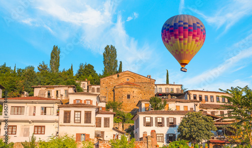 Colorful hot air balloon flying over Sirince village - Traditional turkish (ottoman) village house in Sirince - İzmir, Turkey 
