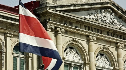 The flag of Costa Rica waving in front of the historical national theater.