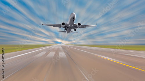 White Passenger plane fly up over take-off runway from airport with motion blur effect.