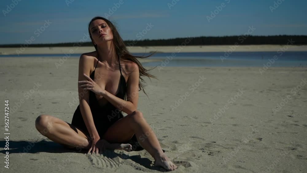 The brunette with long hair fluttering in the wind enjoys the sunshine. sexy looks at the camera holding her hand around her neck and lazed around in the sun The brunette with long hair fluttering in the wind enjoys the sunshine. sexy looks at the camera holding her hand around her neck and lazed around in the sun