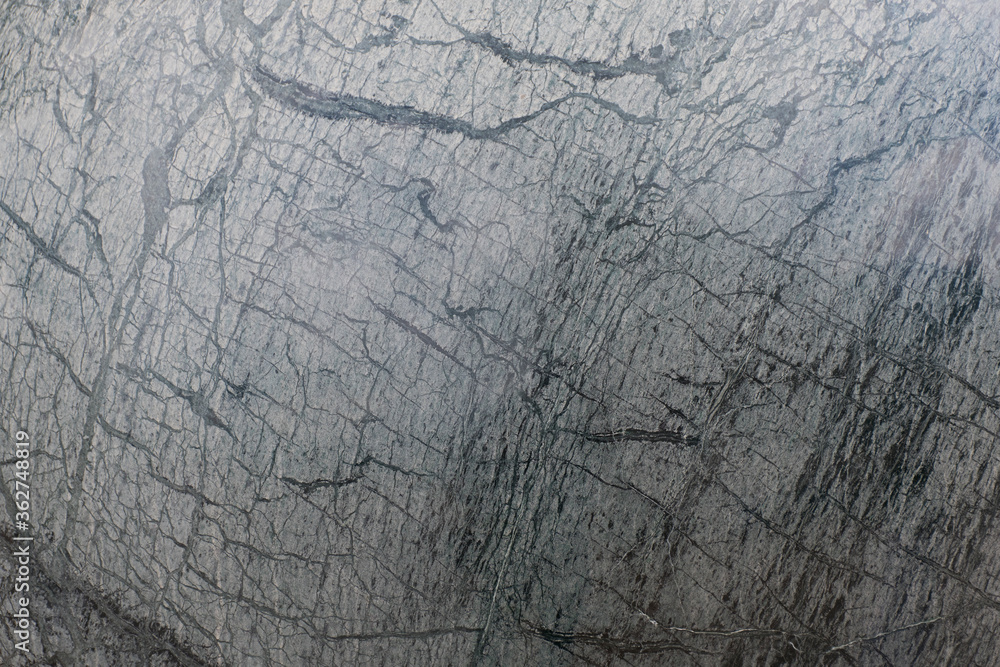 The surface of the sphere has a pattern of black and white and gray. The surface of the sphere has a pattern of black and white and gray.