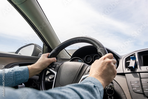 Travel trip car. Happy young man inside vehicle driving in sunny day. Fun driver ride in summer vacation concept.