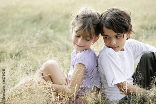 Children sitting back-to-back each other