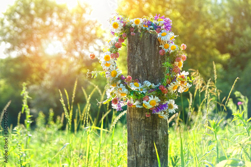 rustic wildflowers wreath. summer flower wreath in garden, sunny day. Farm lifestyle. Summer Solstice Day, Midsummer. floral traditional decor
