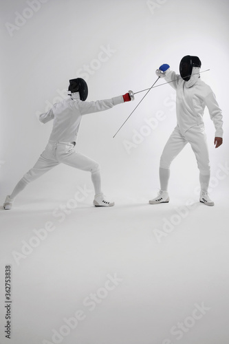 Two men in fencing suits dueling