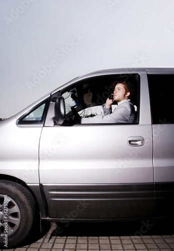 Businessman talking on the phone while driving in the car © ImageHit
