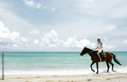 Woman riding a horse on the beach © ImageHit