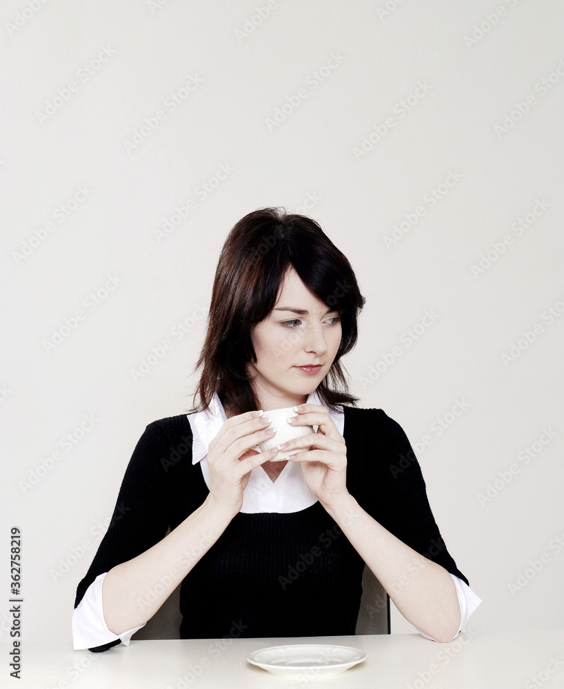 Businesswoman thinking while holding a cup of coffee Businesswoman thinking while holding a cup of coffee