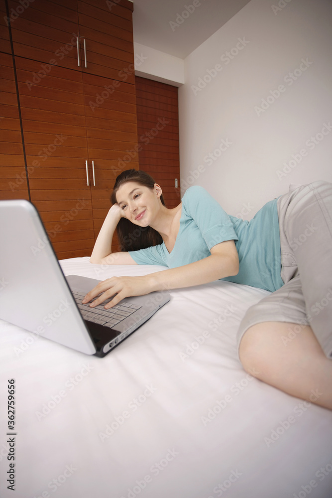 Woman lying in bed using laptop Woman lying in bed using laptop