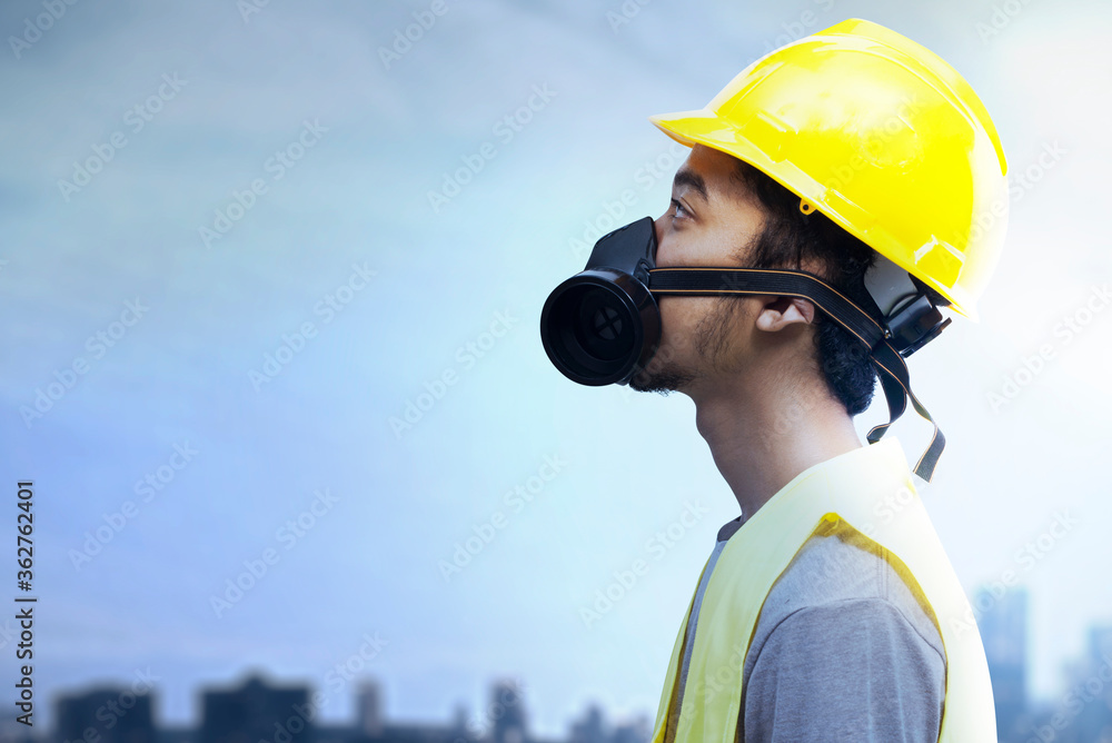 Asian construction worker with hardhat and safety mask standing Asian construction worker with hardhat and safety mask standing