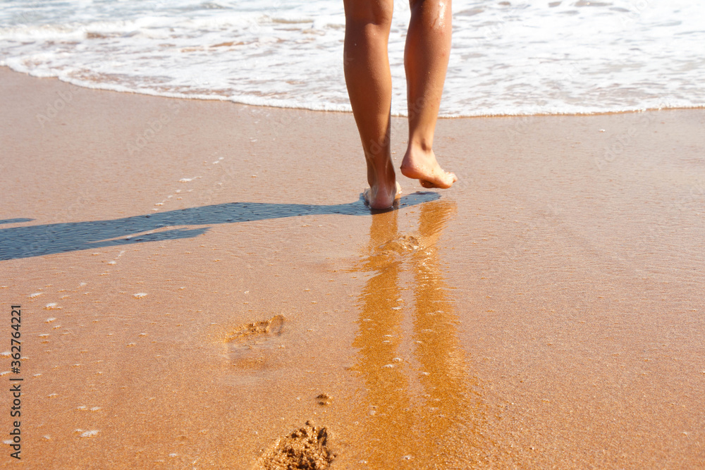 Feet barefoot girl near the water's edge by the sea Feet barefoot girl near the water's edge by the sea