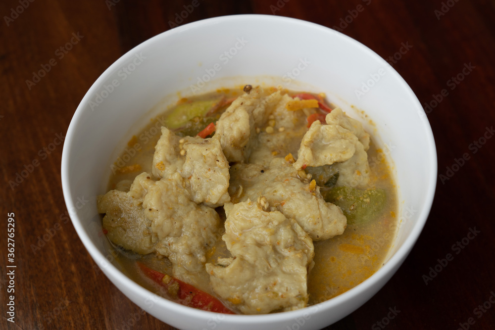 Thai food fish ball in green curry with egg plants and sweet basils in white bowl. Thai food fish ball in green curry with egg plants and sweet basils in white bowl.