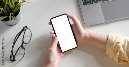 Fotografie Top view Woman sitting and holding blank screen mock up mobile phone