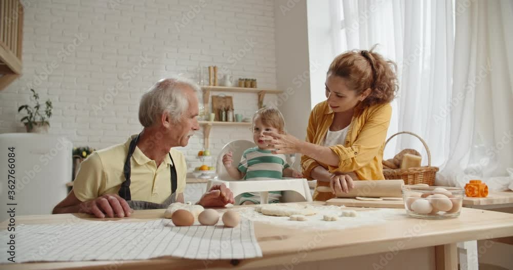 Family of grandfather, mother and little grandson are preparing pastry dough. Family members spending time together, keeping their tradition - family ties concept close up Family of grandfather, mother and little grandson are preparing pastry dough. Family members spending time together, keeping their tradition - family ties concept close up