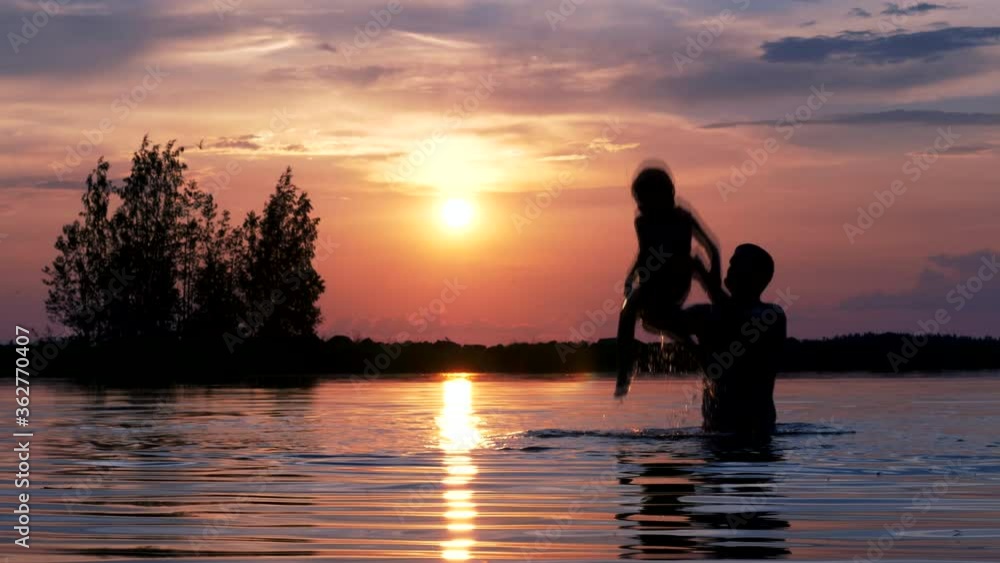 Idyllic silhouette of dad playing with child in water at sunset, slomo Idyllic silhouette of dad playing with child in water at sunset, slomo
